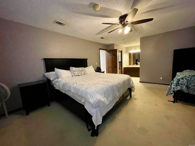 carpeted bedroom featuring connected bathroom, ceiling fan, and a textured ceiling