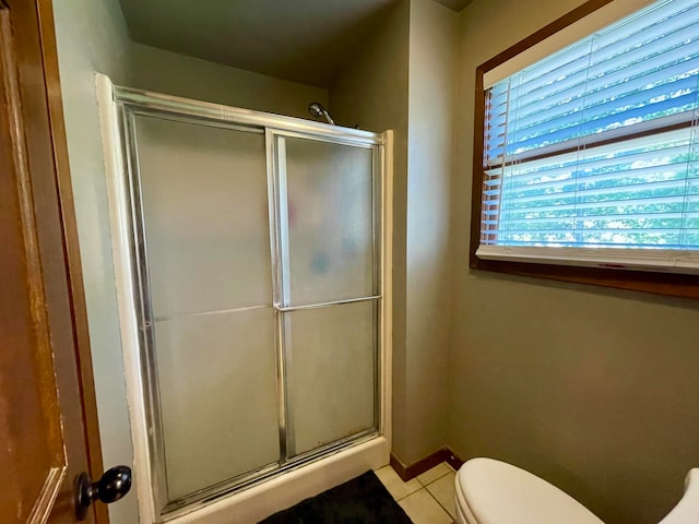 bathroom with toilet, tile patterned floors, and a shower with shower door