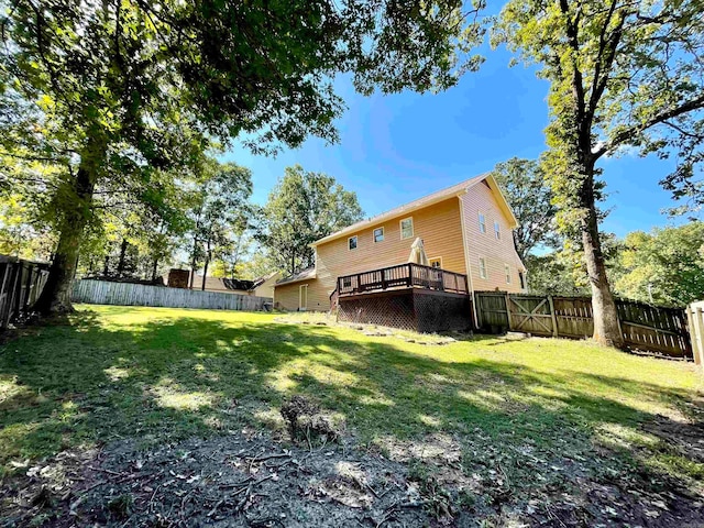 rear view of property with a wooden deck and a yard