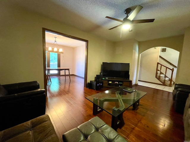 living room featuring wood-type flooring, a textured ceiling, and ceiling fan with notable chandelier