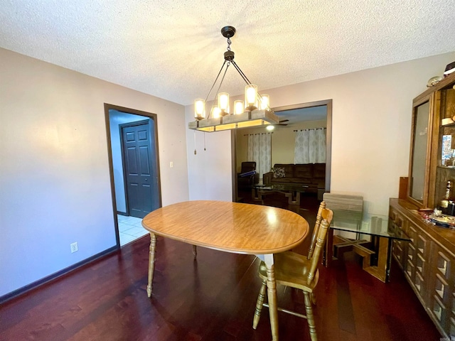 dining room with a notable chandelier, a textured ceiling, and dark hardwood / wood-style flooring