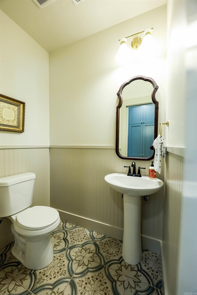 bathroom with toilet and tile patterned floors