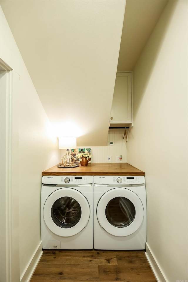 washroom featuring washer and clothes dryer, cabinets, and dark hardwood / wood-style flooring