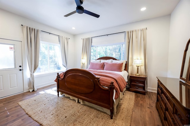 bedroom with multiple windows, wood-type flooring, and ceiling fan