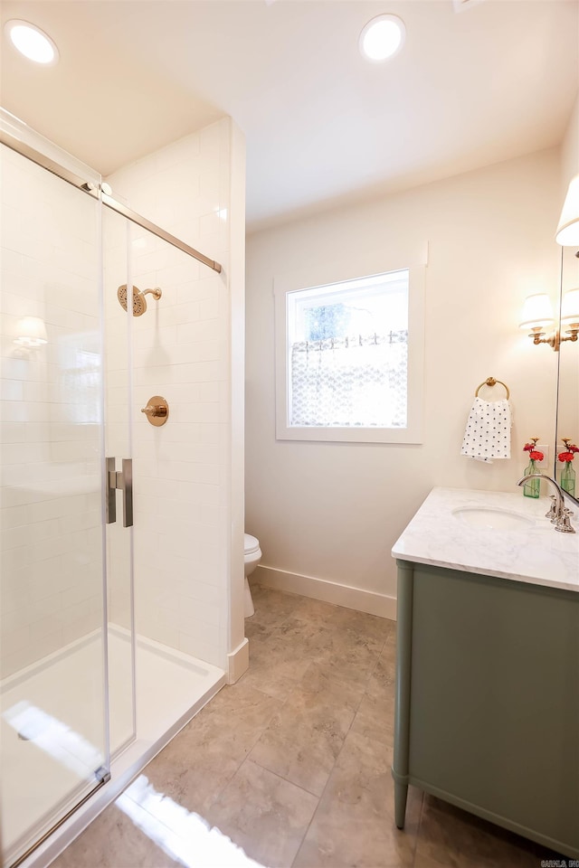 bathroom featuring an enclosed shower, vanity, and toilet