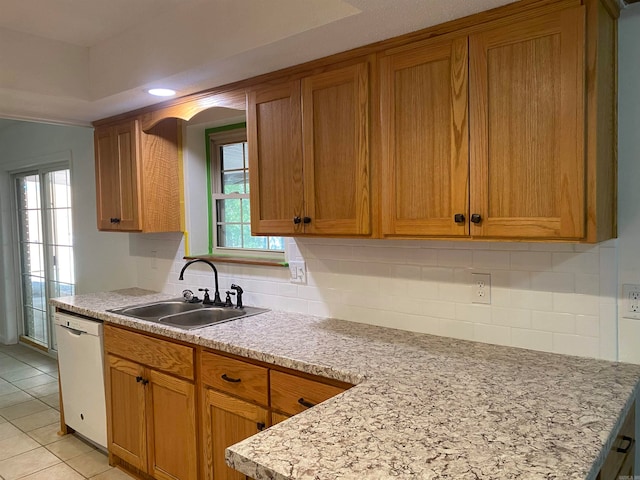 kitchen featuring white dishwasher, sink, tasteful backsplash, and light tile patterned flooring