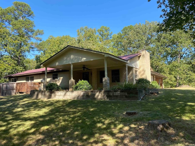 view of property exterior featuring a lawn and ceiling fan