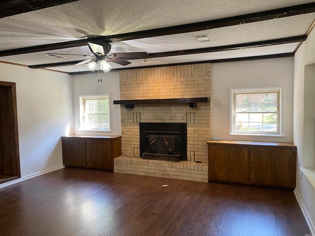 unfurnished living room featuring a textured ceiling, beam ceiling, and dark hardwood / wood-style floors