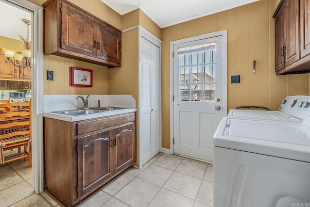 washroom with washing machine and clothes dryer, cabinets, light tile patterned floors, and sink