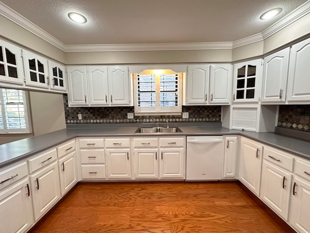 kitchen with dishwasher, sink, white cabinets, decorative backsplash, and hardwood / wood-style floors