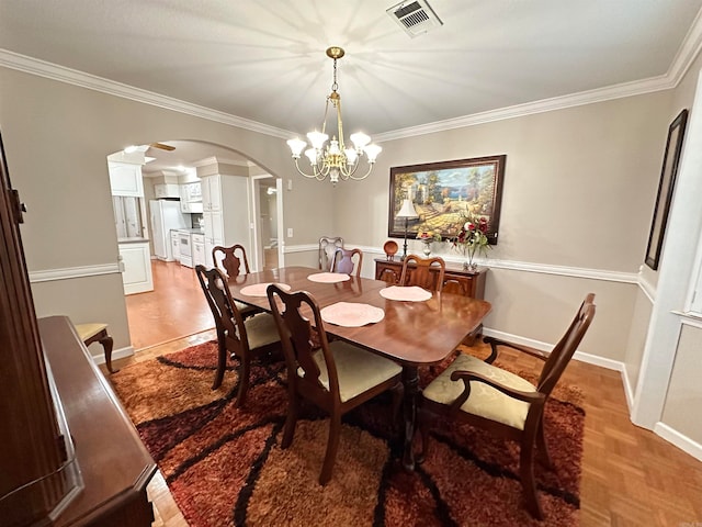 dining space featuring crown molding and an inviting chandelier