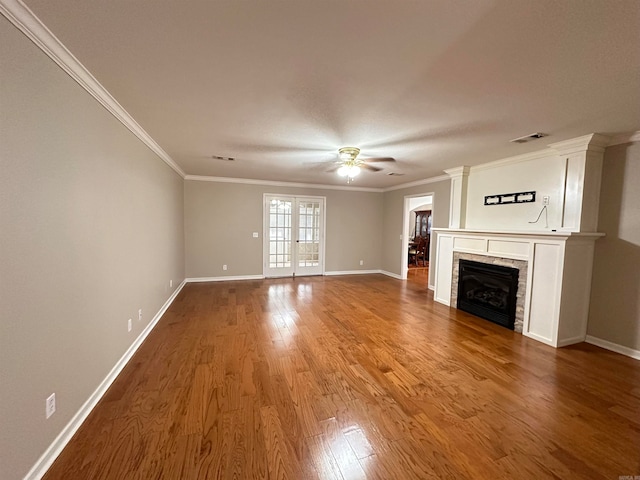 unfurnished living room with ceiling fan, crown molding, hardwood / wood-style floors, and a tiled fireplace