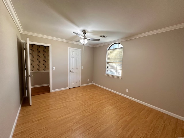 unfurnished bedroom featuring ceiling fan, crown molding, and light hardwood / wood-style floors