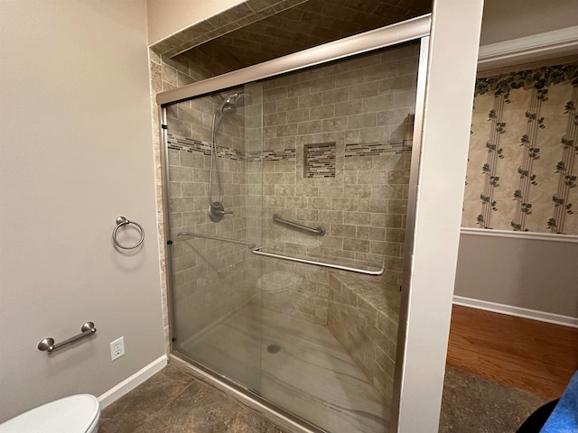 bathroom with wood-type flooring, toilet, and a shower with door