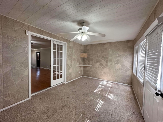 carpeted spare room featuring ceiling fan, wood ceiling, and french doors