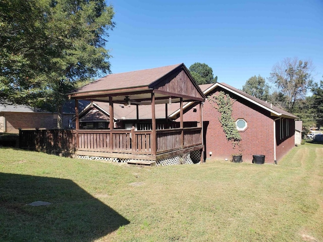 rear view of house featuring a lawn, a deck, and ceiling fan