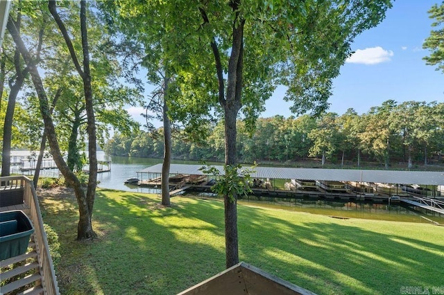 surrounding community with a boat dock, a lawn, and a water view