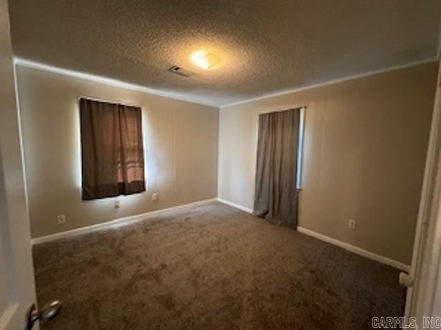 empty room featuring a textured ceiling and carpet floors
