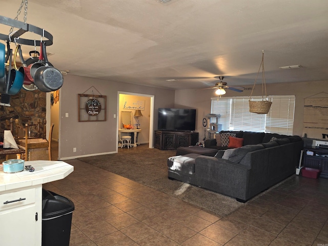 living room with dark tile patterned flooring and ceiling fan