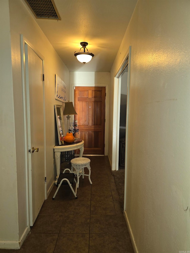 hallway featuring dark tile patterned flooring