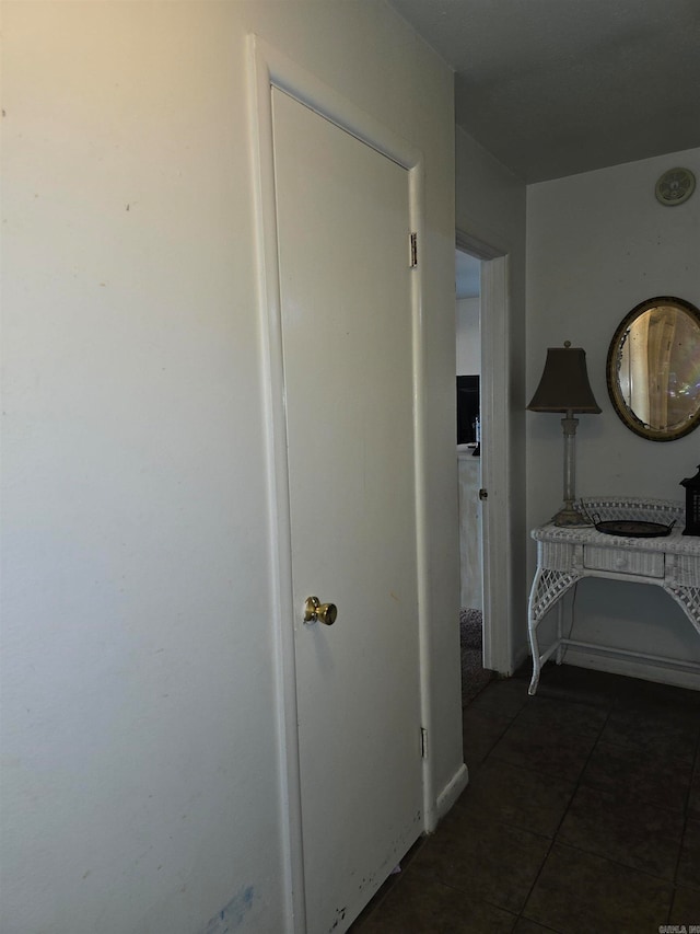 hallway with dark tile patterned flooring