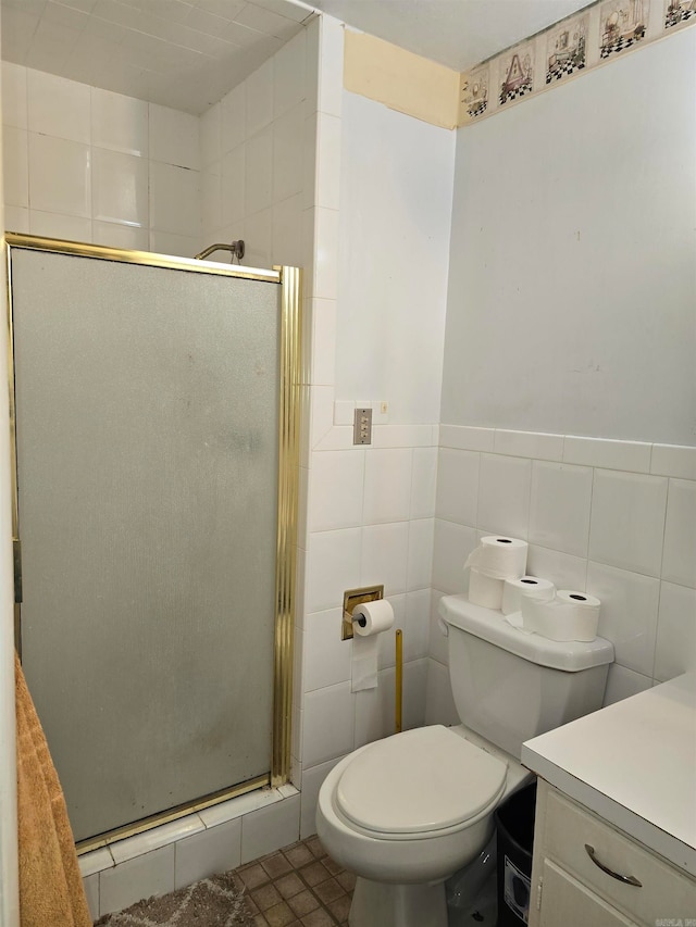 bathroom featuring vanity, tile patterned floors, tile walls, toilet, and a shower with door