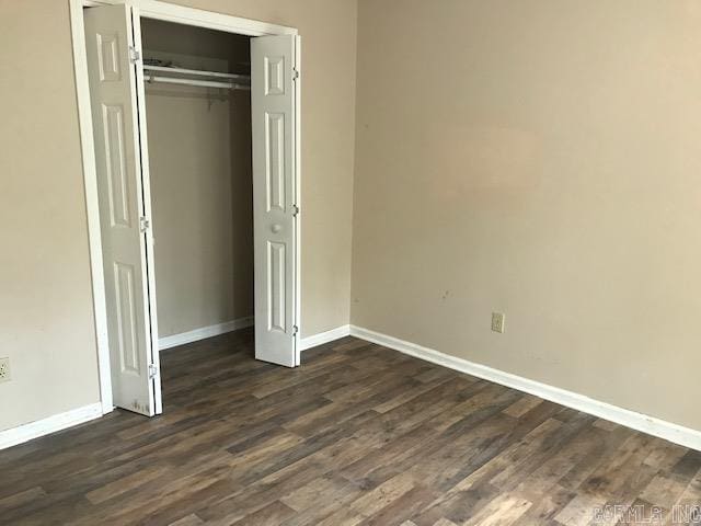 unfurnished bedroom featuring a closet and dark hardwood / wood-style floors