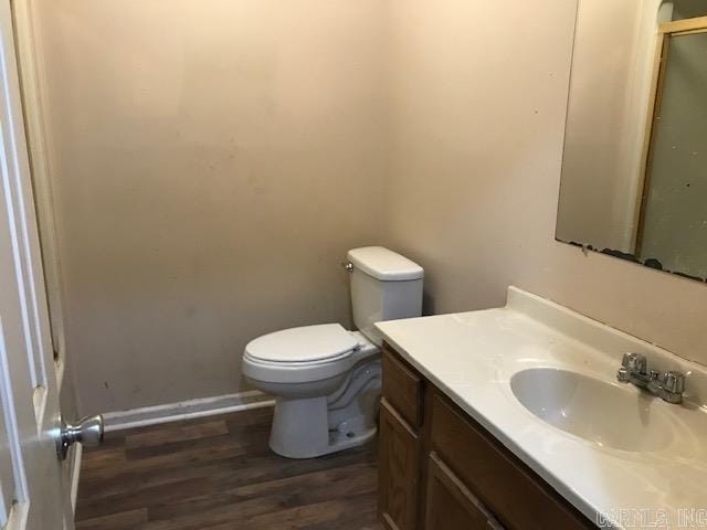 bathroom with wood-type flooring, vanity, and toilet