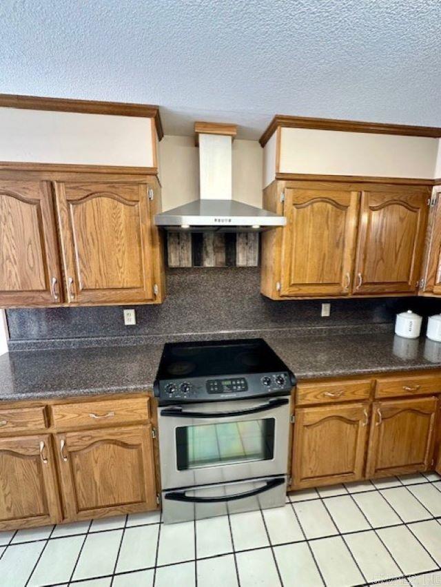 kitchen with tasteful backsplash, crown molding, stainless steel stove, a textured ceiling, and wall chimney exhaust hood