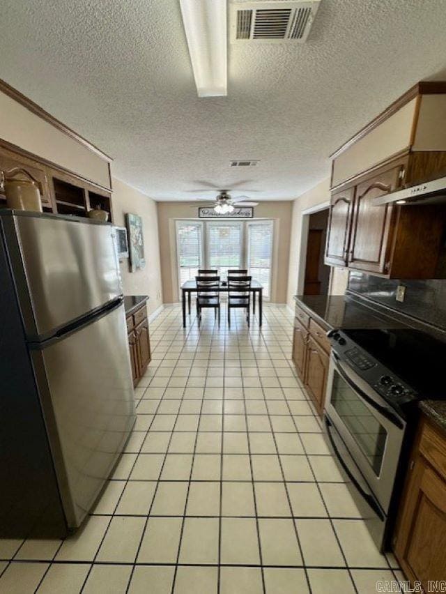 kitchen with appliances with stainless steel finishes, a textured ceiling, ceiling fan, and light tile patterned floors