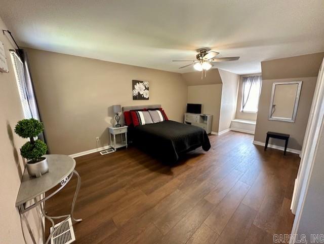 bedroom with dark hardwood / wood-style flooring, ceiling fan, and vaulted ceiling