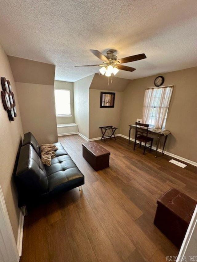 living room with a textured ceiling, hardwood / wood-style flooring, and ceiling fan