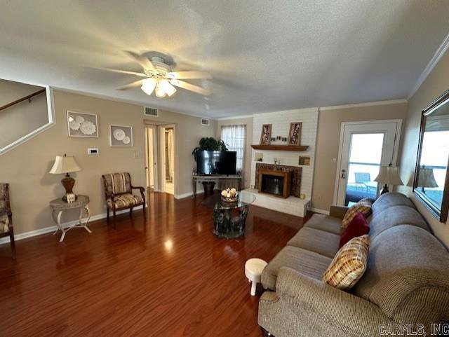 living room featuring a fireplace, a wealth of natural light, ceiling fan, and dark hardwood / wood-style flooring