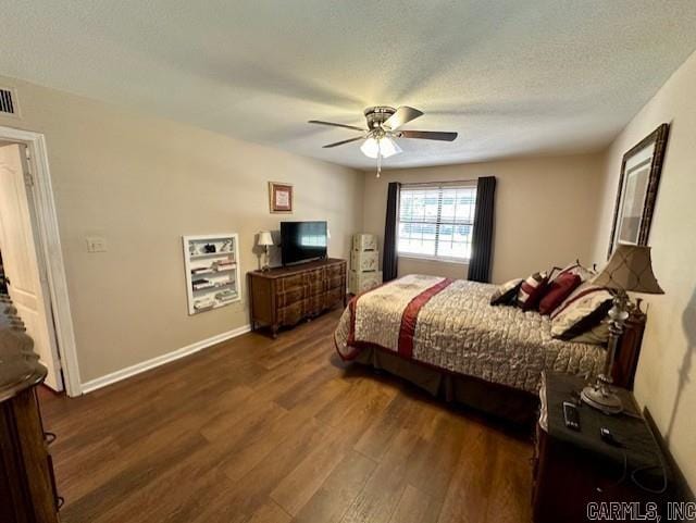 bedroom with ceiling fan, a textured ceiling, and dark hardwood / wood-style flooring