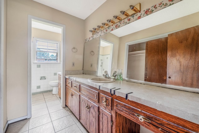 bathroom featuring vanity, tile walls, toilet, and tile patterned floors