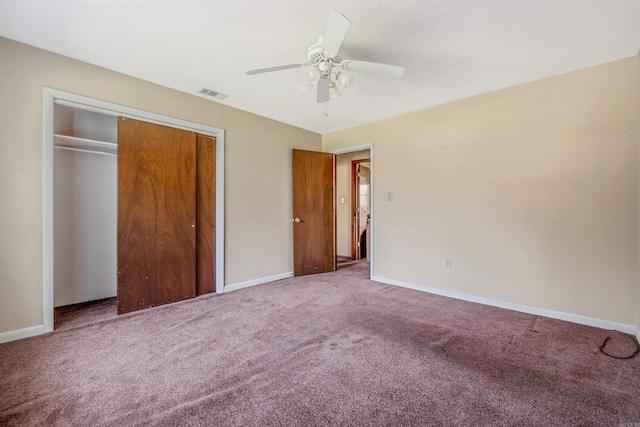 unfurnished bedroom with ceiling fan, a textured ceiling, a closet, and carpet flooring