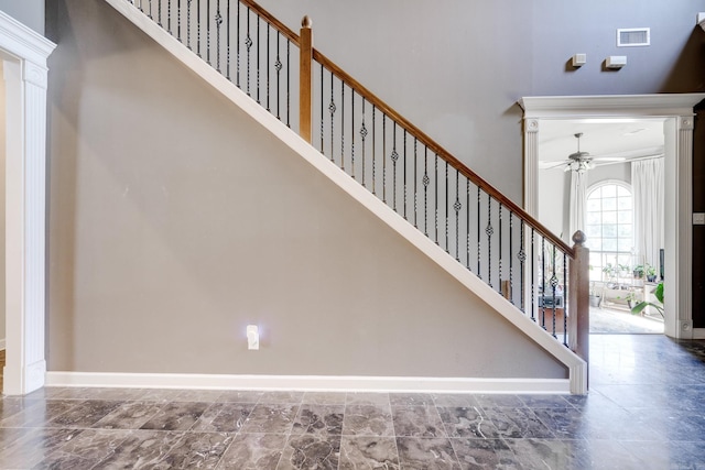 stairway featuring a towering ceiling and crown molding