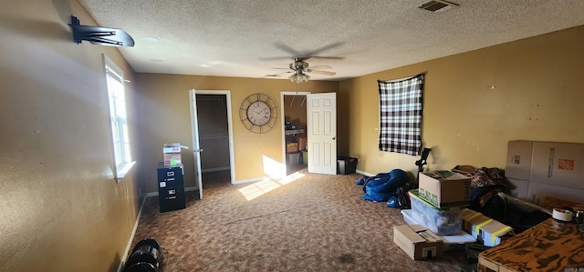 miscellaneous room with ceiling fan, a textured ceiling, and carpet