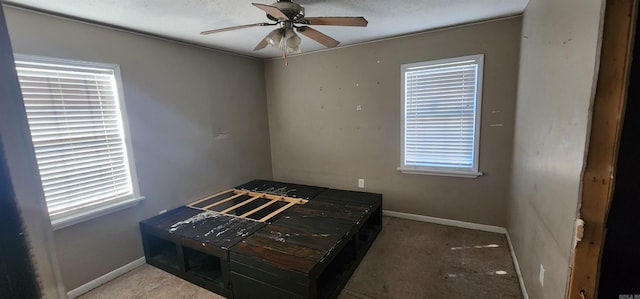 carpeted bedroom featuring a textured ceiling and ceiling fan