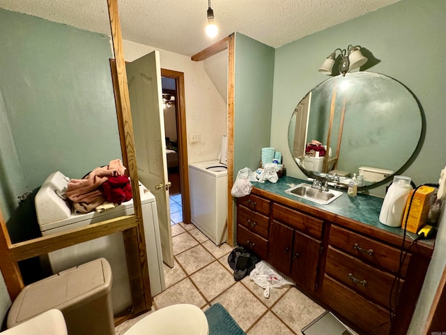 bathroom with washer / clothes dryer, vanity, a textured ceiling, tile patterned flooring, and toilet