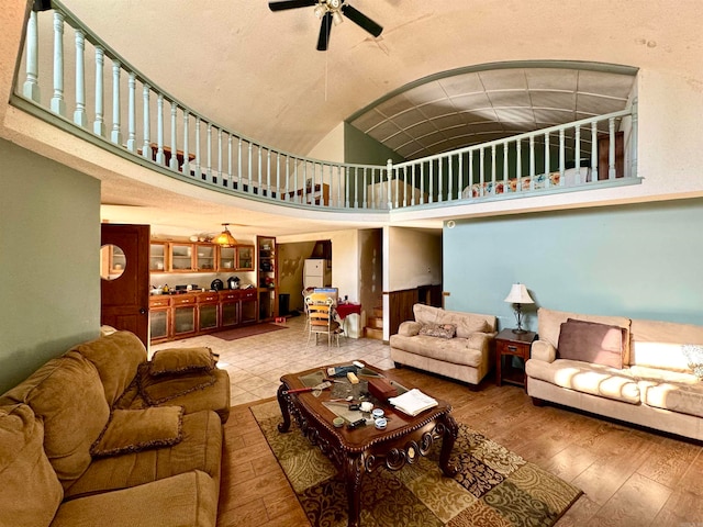 living room featuring high vaulted ceiling, ceiling fan, and hardwood / wood-style floors