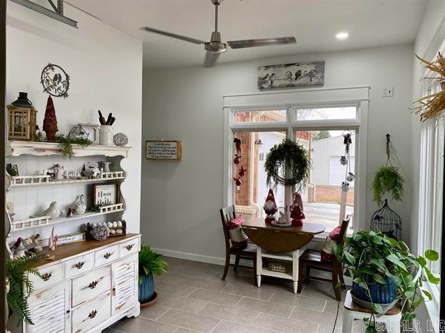 tiled dining space featuring ceiling fan