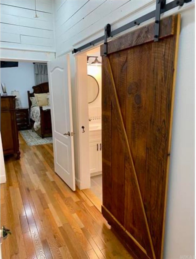 hall featuring a barn door and light hardwood / wood-style floors