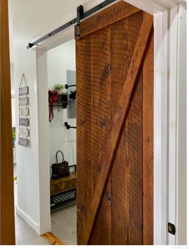 interior space featuring light tile patterned flooring and a barn door