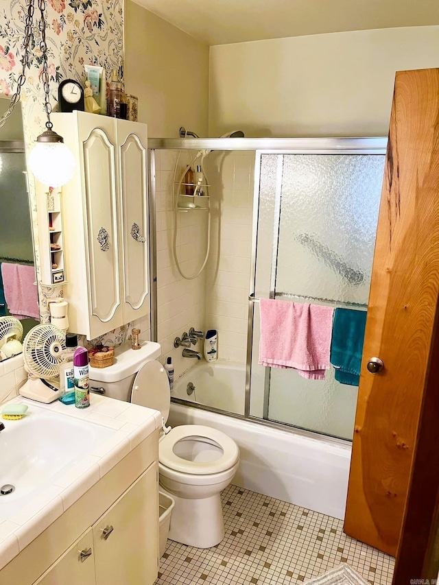 full bathroom with vanity, toilet, combined bath / shower with glass door, and tile patterned floors