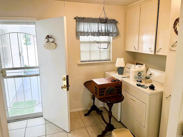 kitchen featuring pendant lighting, independent washer and dryer, light tile patterned floors, and white cabinets