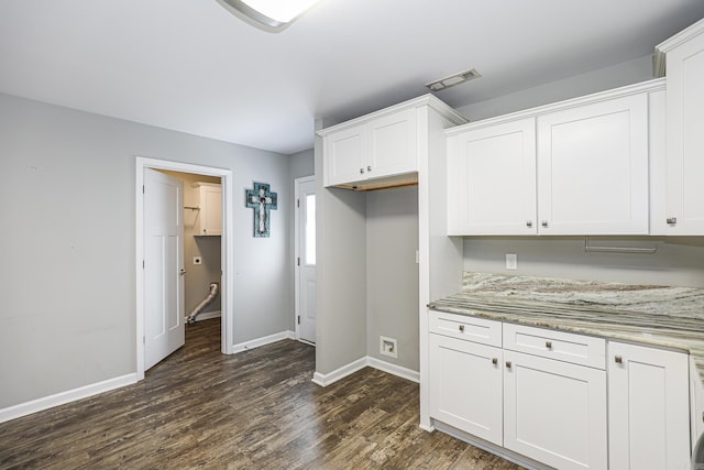 kitchen featuring white cabinetry, light stone countertops, and dark wood-type flooring