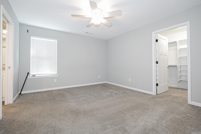 carpeted spare room featuring ceiling fan