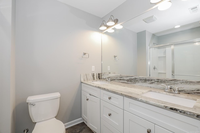 bathroom with a shower with door, toilet, and vanity