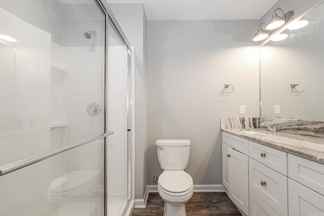 bathroom featuring wood-type flooring, walk in shower, vanity, and toilet